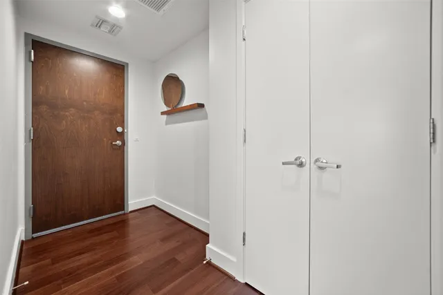 a view of empty room with wooden floor