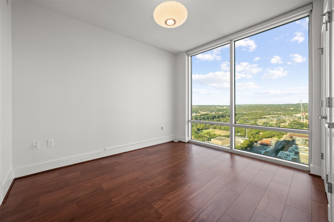 300 Bowie Street, Unit 2405 Austin, TX 78703 - Photo 23 of 39 an empty room with wooden floor and windows