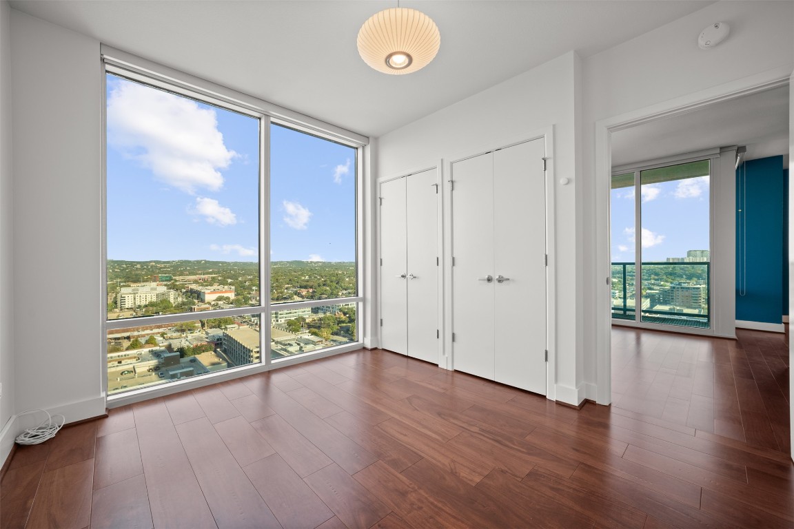 300 Bowie Street, Unit 2405 Austin, TX 78703 - Photo 24 of 39 an empty room with wooden floor and windows
