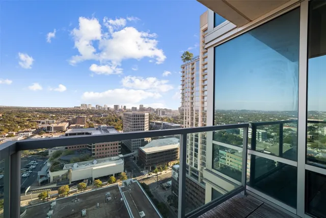 a view of a balcony with wooden floor and a city view