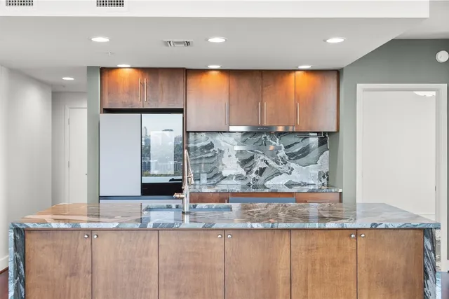 a view of a kitchen with kitchen island a sink and wooden floor