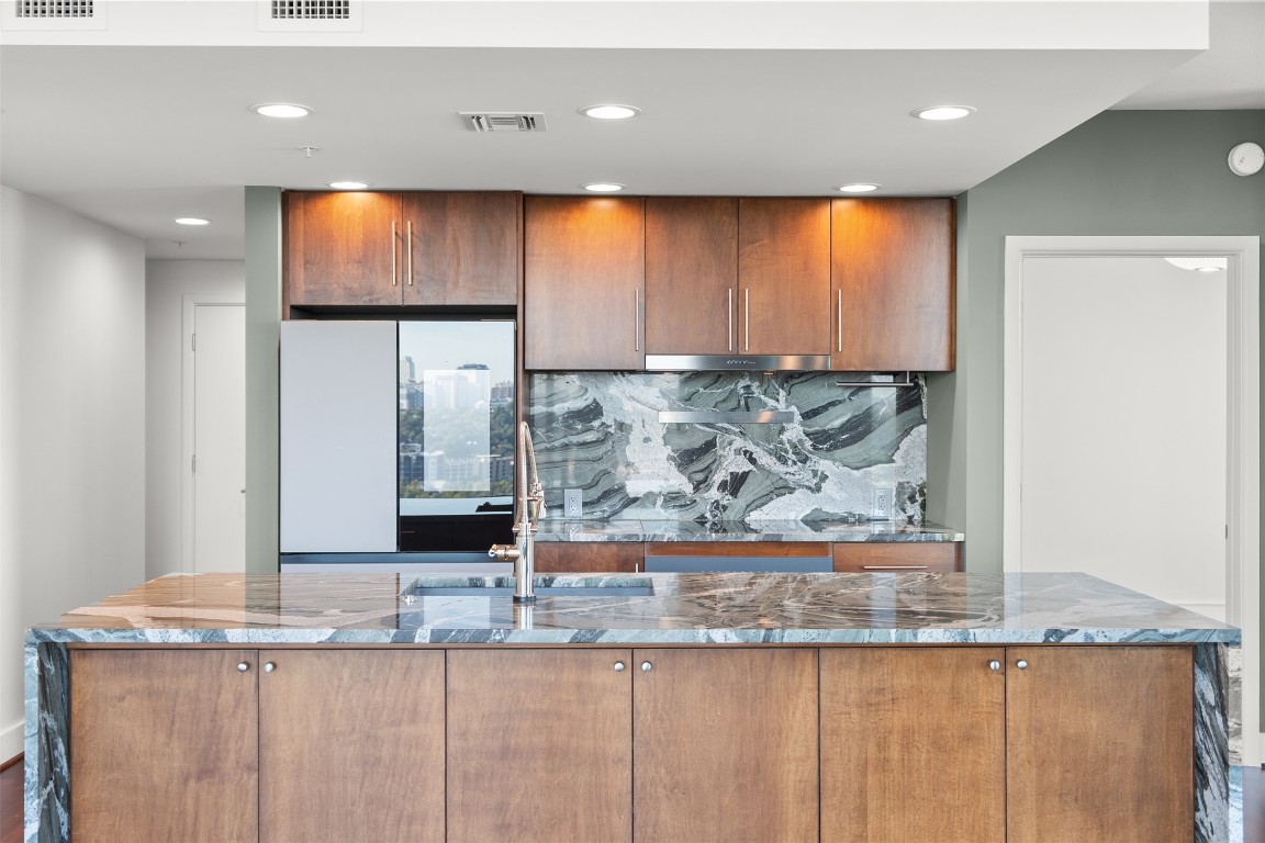 300 Bowie Street, Unit 2405 Austin, TX 78703 - Photo 4 of 39 a view of a kitchen with kitchen island a sink and wooden floor