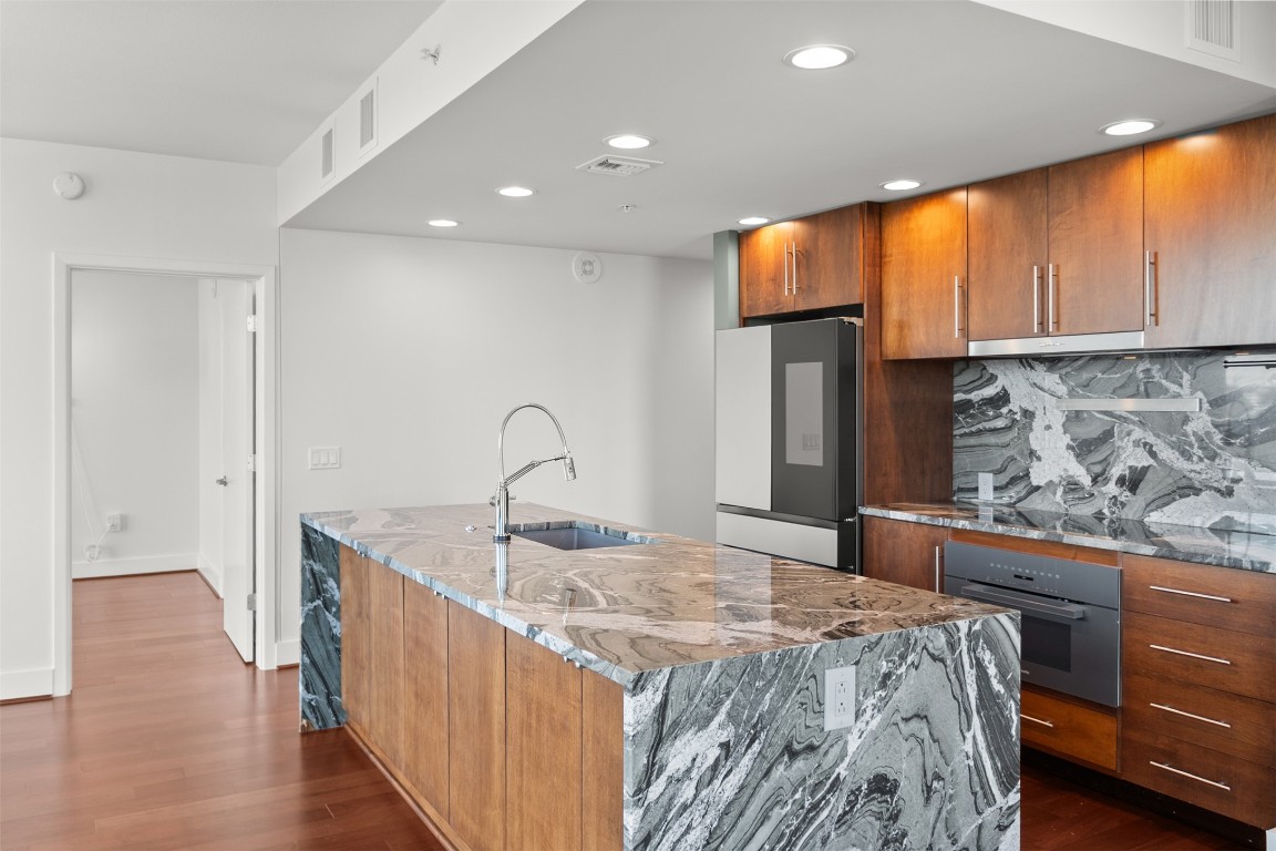 300 Bowie Street, Unit 2405 Austin, TX 78703 - Photo 5 of 39 a bedroom with a large bed and wooden floor