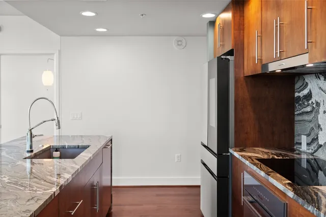 a kitchen with granite countertop a sink and a stove top oven