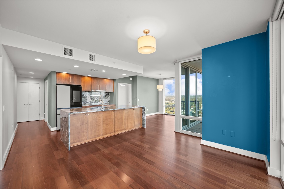 300 Bowie Street, Unit 2405 Austin, TX 78703 - Photo 9 of 39 a large living room with stainless steel appliances kitchen island wooden floors and white walls