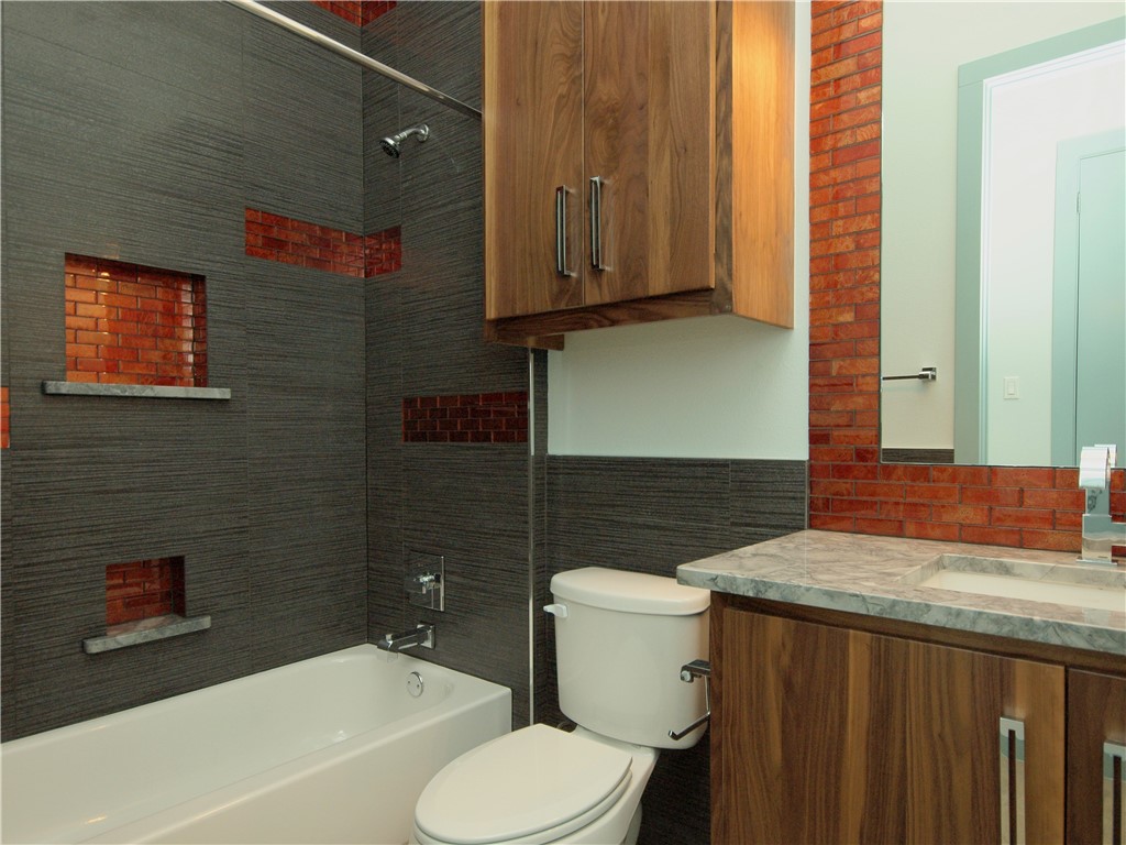 306 Franklin Boulevard, Unit B Austin, TX 78751 - Photo 15 of 23 a bathroom with a granite countertop toilet sink and mirror