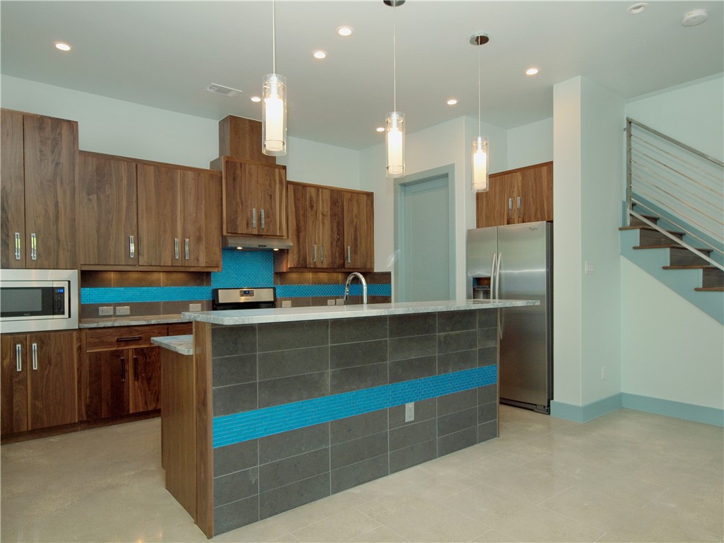 306 Franklin Boulevard, Unit B Austin, TX 78751 - Photo 6 of 23 a kitchen with kitchen island granite countertop a sink a counter top space and cabinets