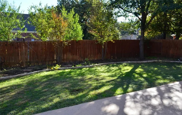 a view of backyard with wooden fence