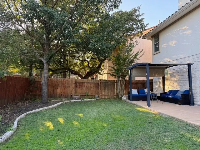 a view of a chair and table in backyard of the house