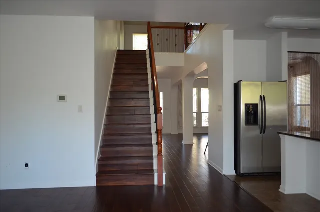 a view of a hallway with wooden floor and staircase