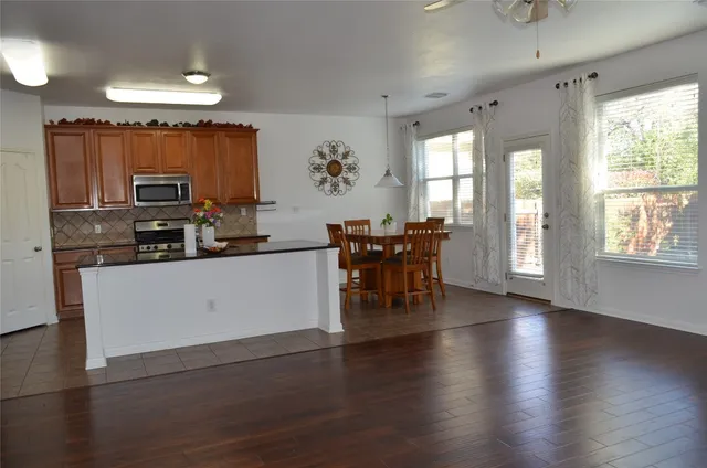 a kitchen with stainless steel appliances a dining table chairs and granite counter tops