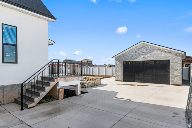 1426 South 1450th Street West Mapleton, UT 84664 - Photo 45 of 50 Detached garage with light-toned stone veneer and a black overhead door