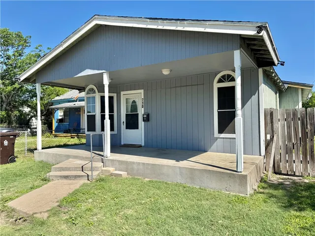 a backyard of a house with yard and outdoor seating