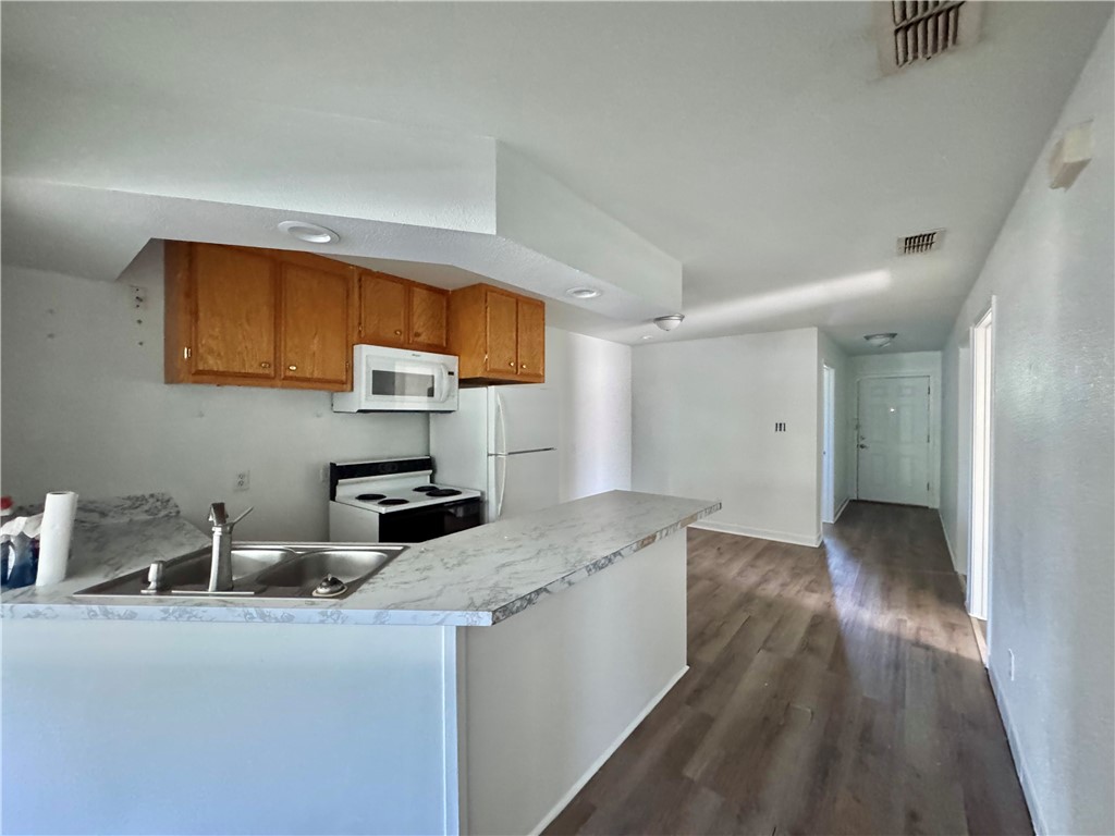 710 East C Avenue Kingsville, TX 78363 - Photo 4 of 13 a kitchen with granite countertop a sink and wooden cabinets