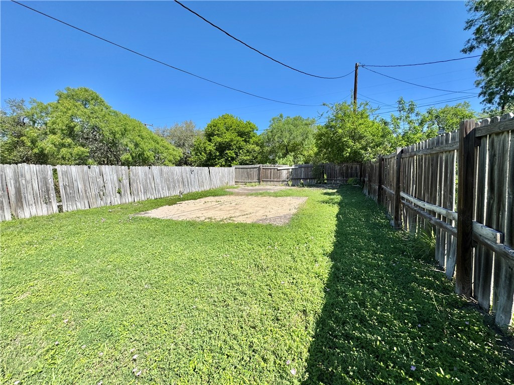 710 East C Avenue Kingsville, TX 78363 - Photo 10 of 13 a view of a backyard with potted plants and wooden fence
