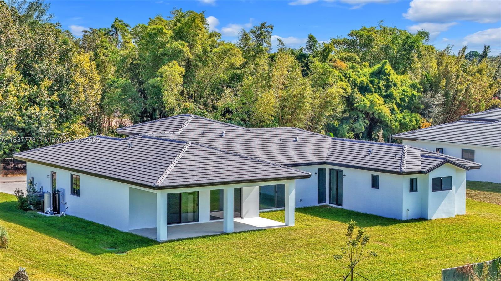 a aerial view of a house with a yard potted plants and large tree