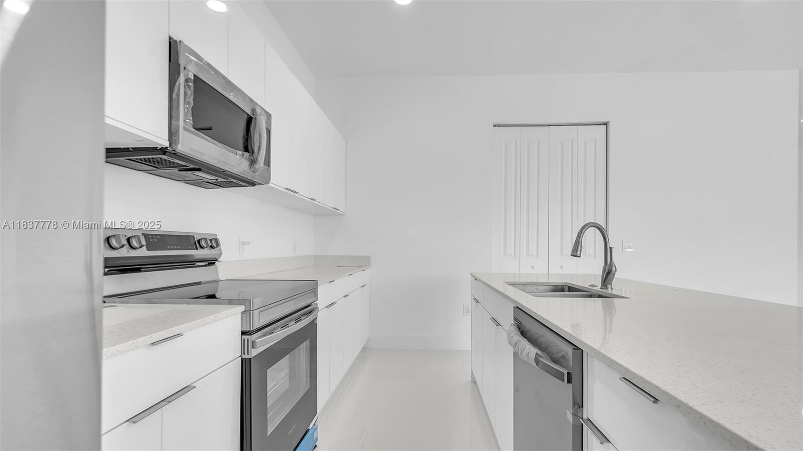 23120 Southwest 154th Court Miami, FL 33170 - Photo 6 of 51 a kitchen with stainless steel appliances white cabinets and a sink