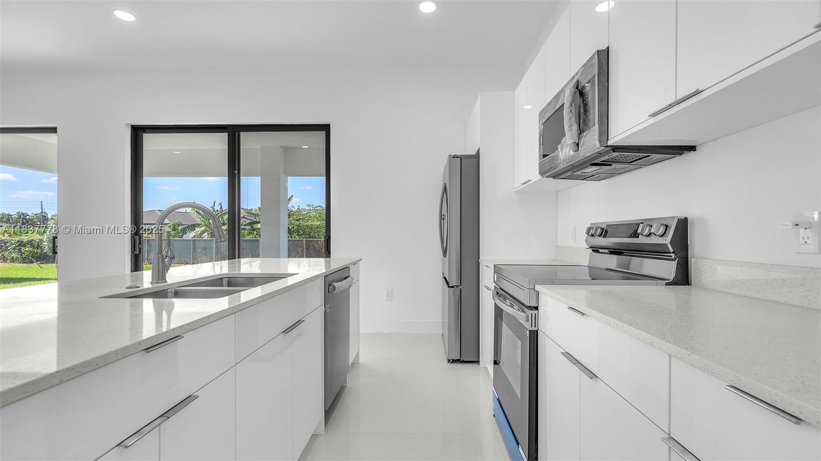 23120 Southwest 154th Court Miami, FL 33170 - Photo 7 of 51 a kitchen with stainless steel appliances a sink a stove and a refrigerator