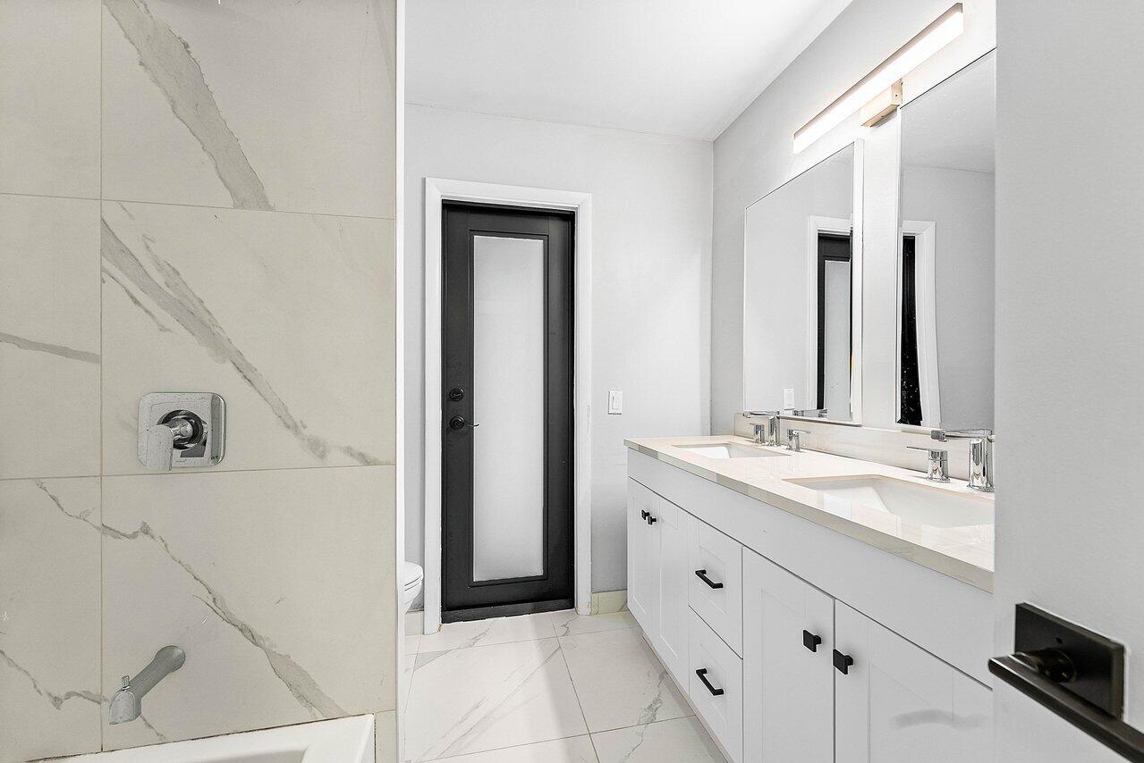 2425 Northwest 36th Street Boca Raton, FL 33431 - Photo 19 of 31 a spacious bathroom with a double vanity sink a mirror and shower