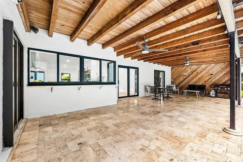 a view of a patio with table and chairs with wooden floor and fence