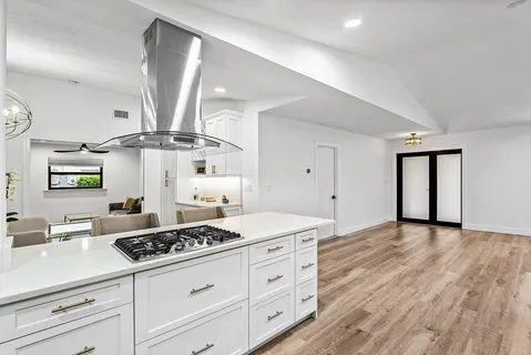 a kitchen with a stove cabinets and wooden floor