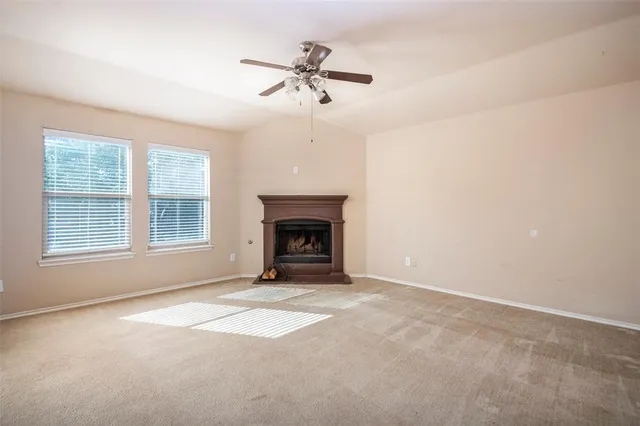 a view of an empty room with a fireplace and a window