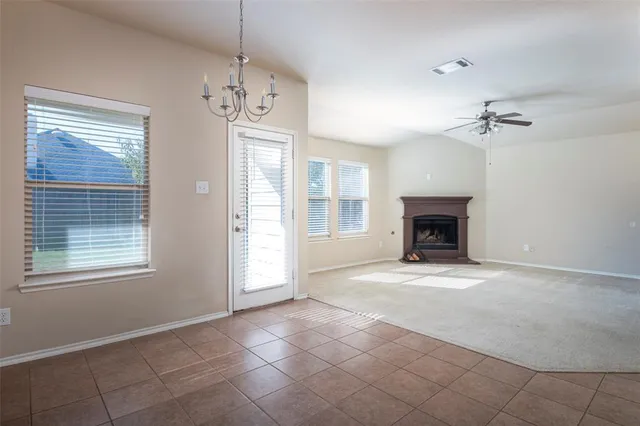 a view of an empty room with a fireplace and a window
