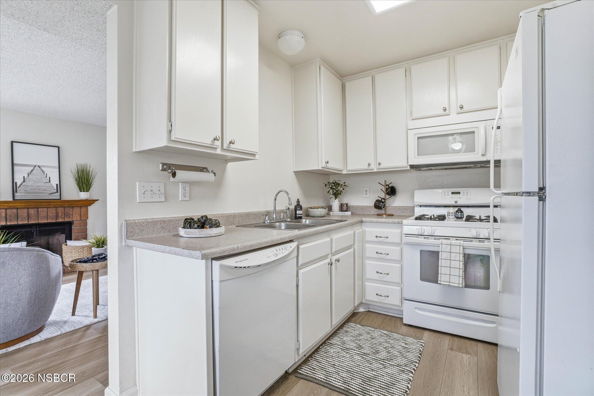 1192 Sumner Place, Unit D Santa Maria, CA 93455 - Photo 7 of 18 a kitchen with stainless steel appliances granite countertop a stove and white cabinets