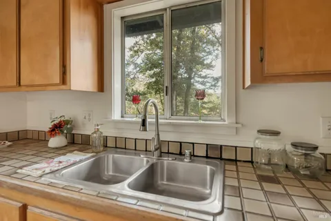 a kitchen sink with a stove and cabinets