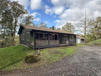 a view of a house with a yard and fence