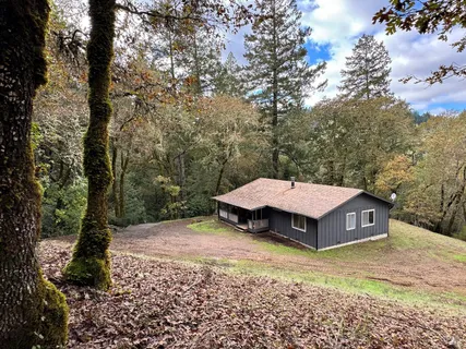 a view of a house with a yard and sitting area