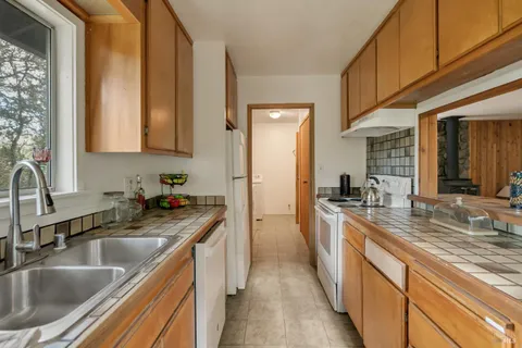a kitchen with stainless steel appliances granite countertop a sink stove and cabinets