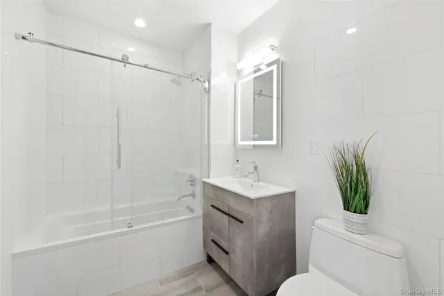 a bathroom with a granite countertop sink a toilet and shower