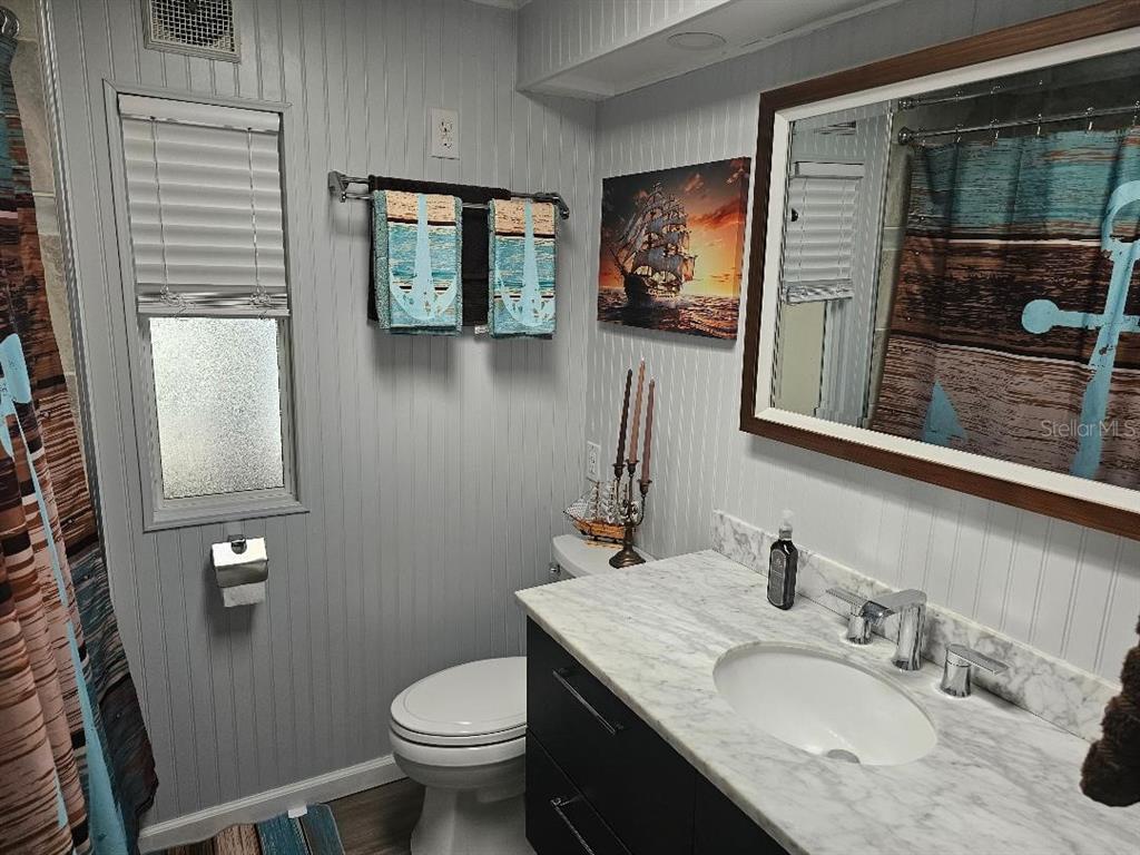 5619 Bayshore Road, Unit 115 Palmetto, FL 34221 - Photo 11 of 21 a bathroom with a granite countertop sink toilet and mirror