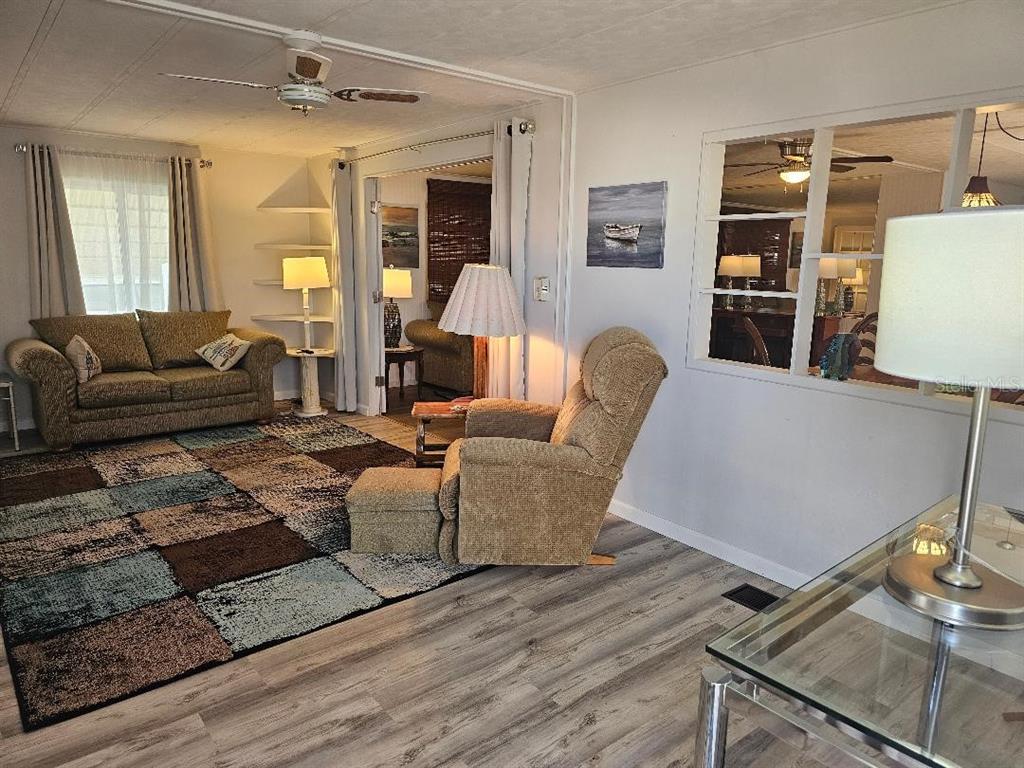 5619 Bayshore Road, Unit 115 Palmetto, FL 34221 - Photo 2 of 21 a living room with furniture and wooden floor