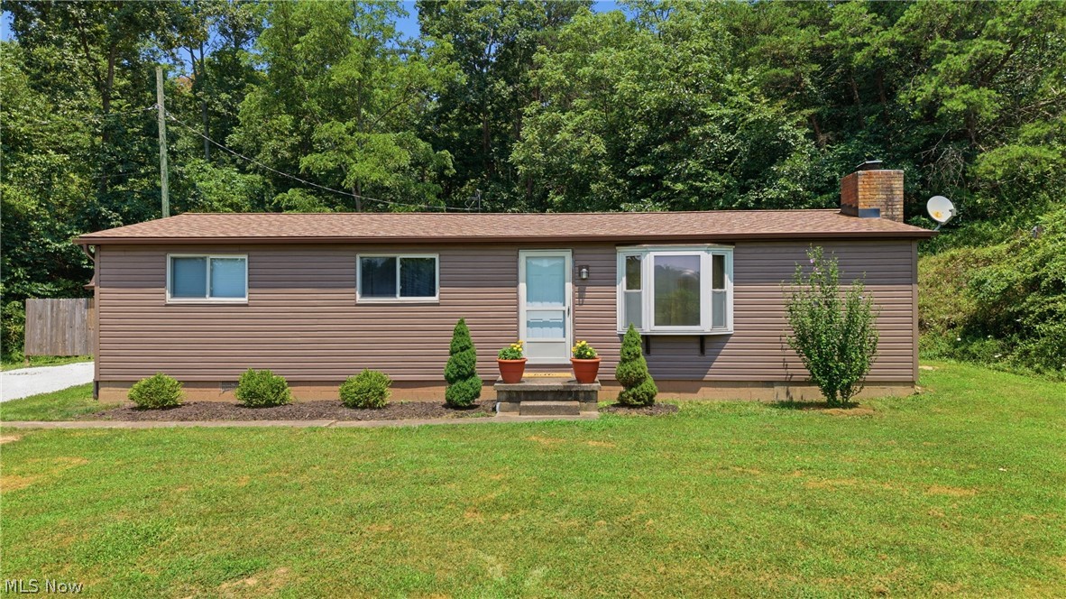 337 Wadesville Road Washington, WV 26181 - Photo 1 of 36 Ranch-style exterior with brown vinyl siding, a brown shingle roof, and a prominent bay window