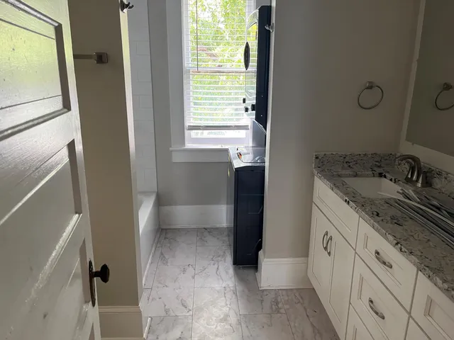 a bathroom with a granite countertop sink a toilet and a shower