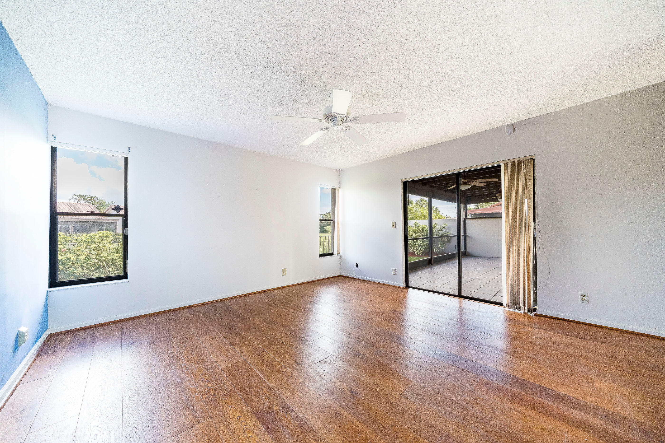 7723 Solimar Circle Boca Raton, FL 33433 - Photo 24 of 40 an empty room with wooden floor chandelier fan and windows