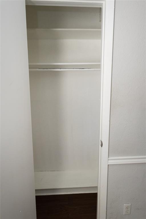 6919 West Cleburne Road Fort Worth, TX 76133 - Photo 25 of 40 Integrated closet storage featuring multiple shelving units, a clothing rod, and wood-finish flooring