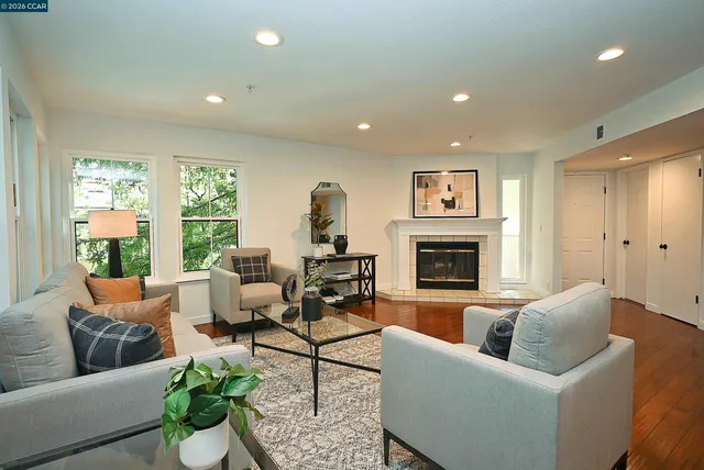 a living room with furniture fireplace and a large window