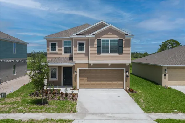 a front view of a house with a yard and garage