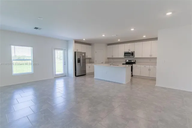 a view of kitchen with refrigerator sink microwave and cabinets