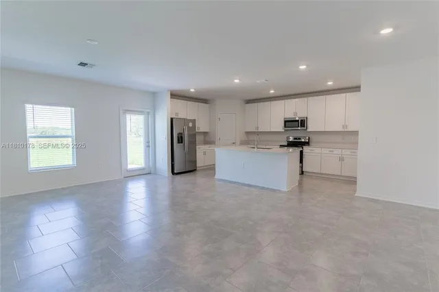 a view of a kitchen with a sink and a refrigerator