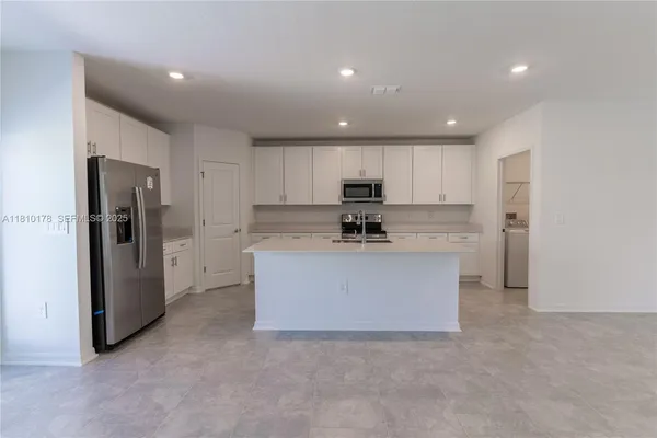 a view of kitchen with refrigerator sink microwave and cabinets