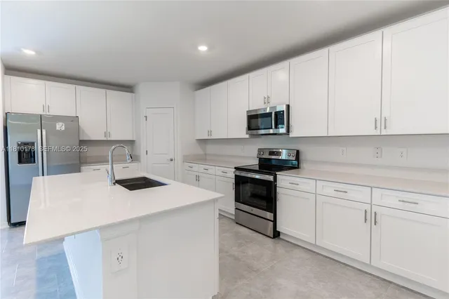 a kitchen with white cabinets and stainless steel appliances