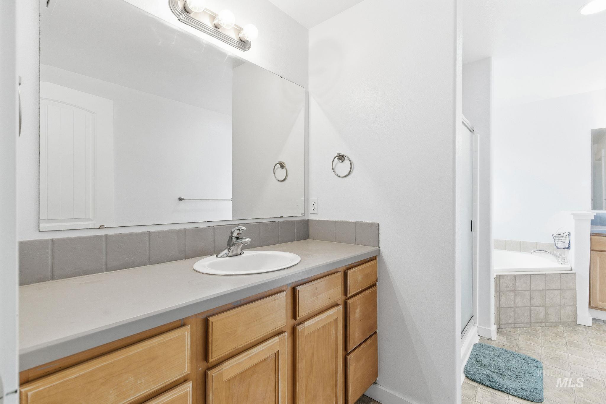 2520 Summercrest Street Caldwell, ID 83607 - Photo 33 of 42 Bathroom with vanity, a bath, a stall shower, and light tile patterned flooring