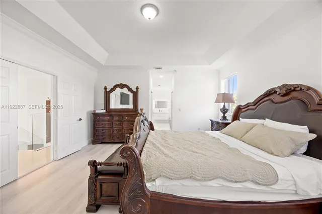 a spacious bedroom with a bed and dresser