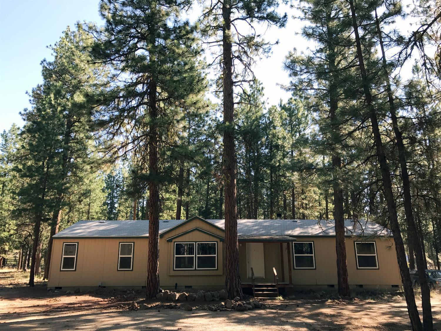 This lovely home in the woods sits on 2.