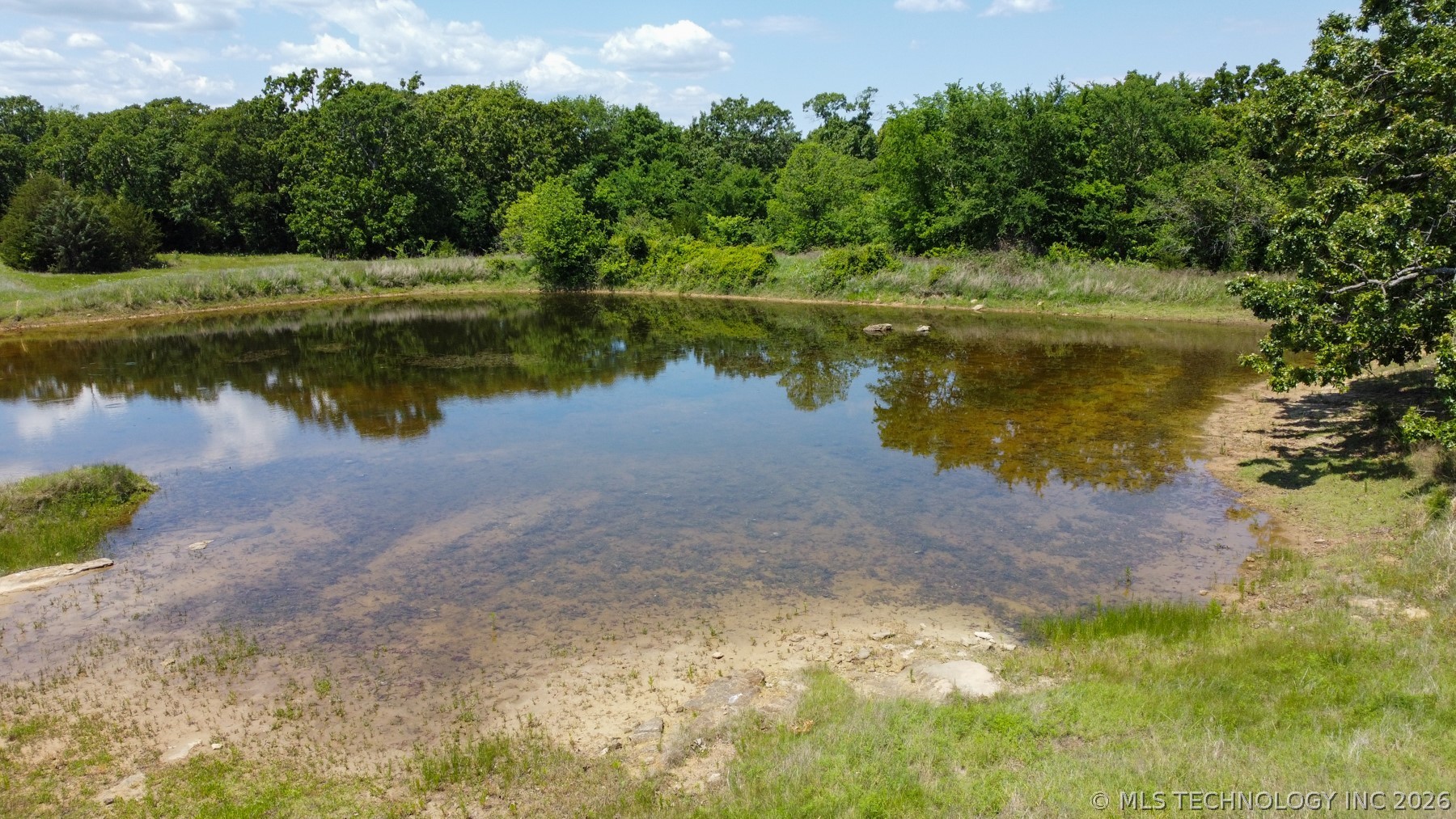 13248 North 3540th Road Maud, OK 74854 - Photo 19 of 98 Natural pond with a clear, reflective surface