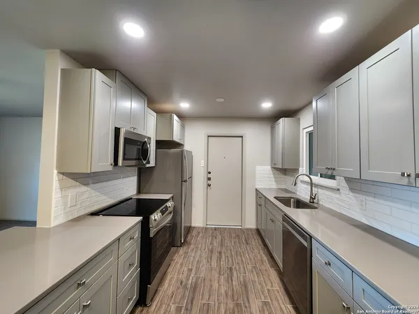 a kitchen with stainless steel appliances a sink stove and refrigerator